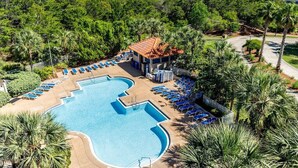 Ein Resort mit großem Pool, Liegestühlen und Blick auf den Ozean.