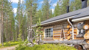 A log cabin with a chimney, a number '7' sign, and a window. - Hankipolku 7b / ukuli by Interhome (Ylläsjärvi)