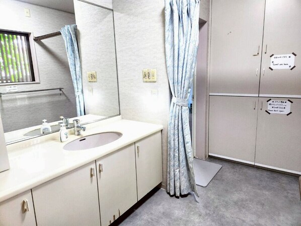 A bathroom with a sink, mirror, and cabinets.