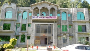 A hotel with a stone facade, multiple windows, and a reception area. - Pine View hotel and Restaurant (Balakot)