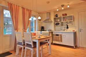 Una cocina compacta con comedor, microondas y estufa.