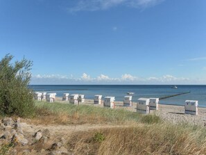 A beach with white beach huts labeled V19, V27, V31, and V21. - Haus Seepferdchen Whg. SP2 (Ostseebad Boltenhagen)