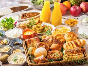 A variety of breakfast foods including pastries, fruits, and beverages.