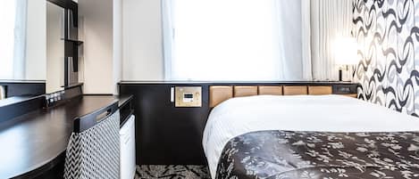 Une chambre d’hôtel comprenant un lit, un bureau, une chaise, un miroir, une fenêtre avec des rideaux et un panneau de commande fixé au mur.