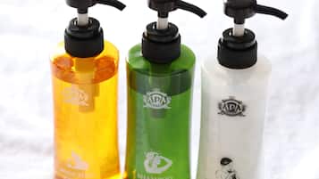 Tres ampolles de productes de bany de l'hotel AP: sabó corporal, xampú i condicionador.