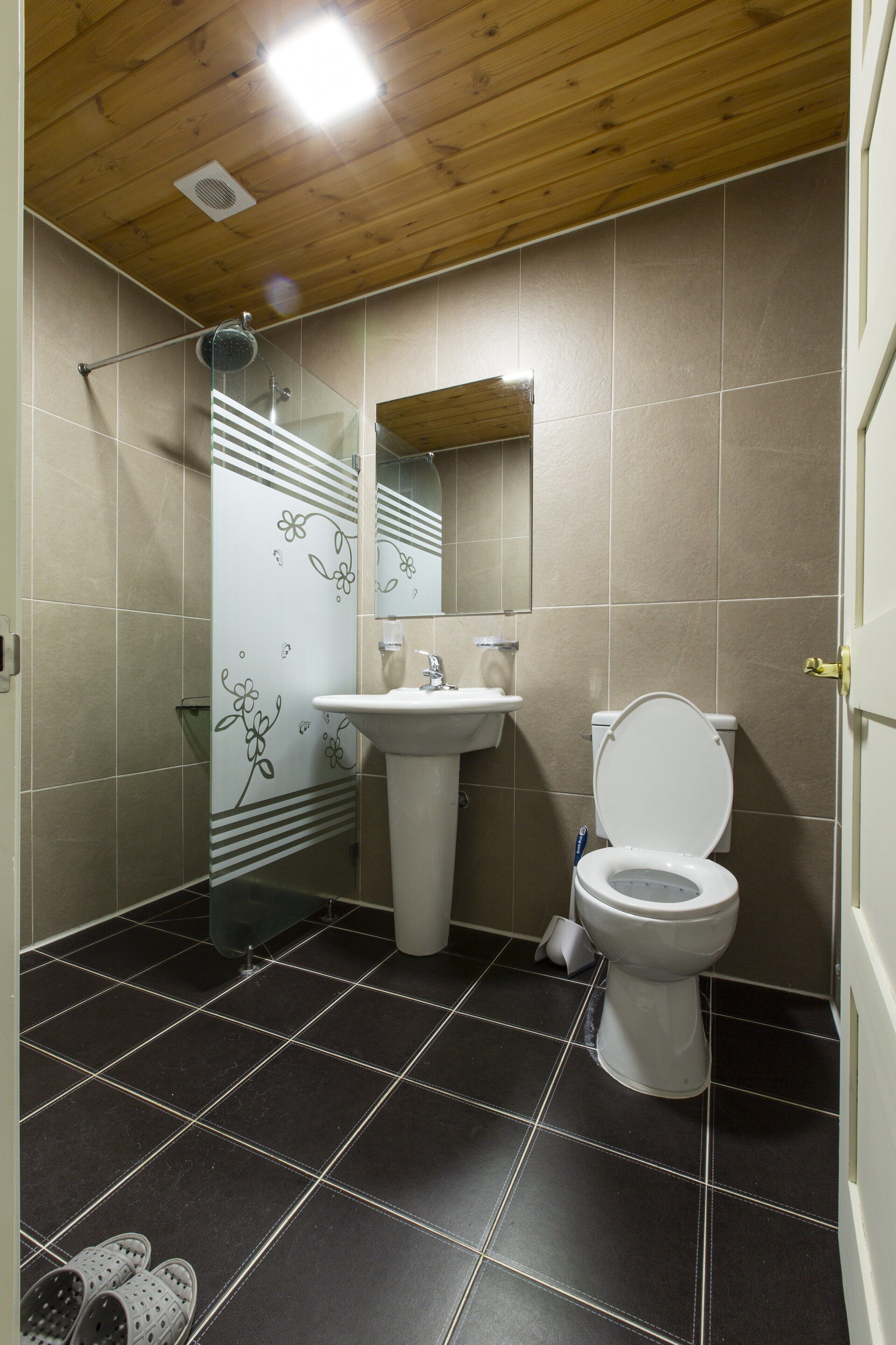 A bathroom with a shower, sink, and toilet.