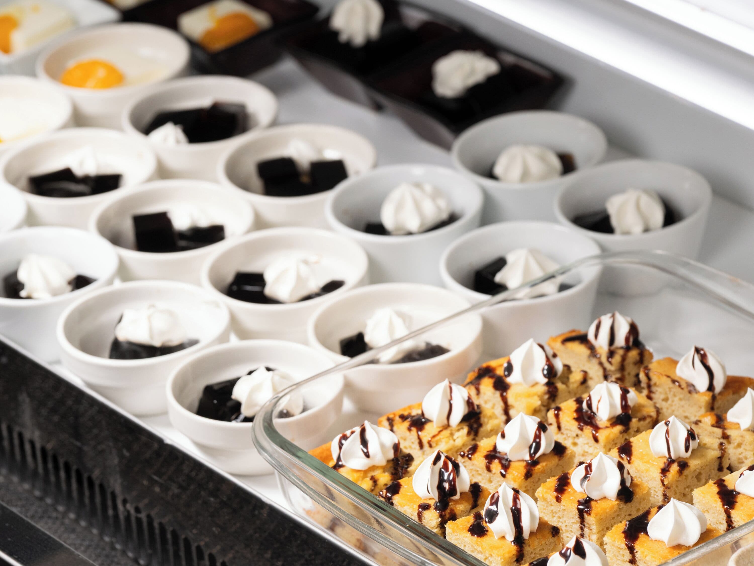 A dessert display with various sweets in bowls and a glass dish.
