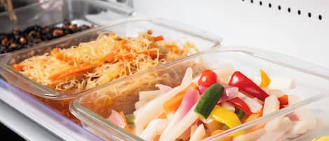 A buffet with various food items including sliced vegetables and cheese.