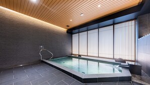 A modern indoor swimming pool with a wooden ceiling, tiled floor, and large windows. - HOTEL Kazusaya (Tokyo)