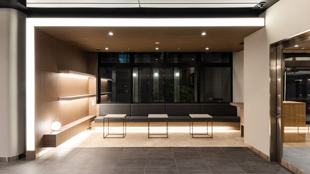 A modern waiting area with a bench, three tables, and a glass partition. - HOTEL Kazusaya (Tokyo)