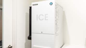 A white ice machine with the word "ICE" prominently displayed, a power button, and a push button.