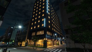 A modern hotel with a prominent sign, multiple floors, and a well-lit entrance. - HOTEL Kazusaya (Tokyo)