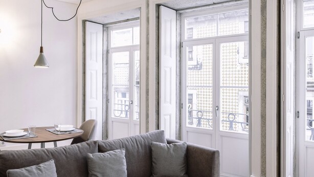 A modern living room with a grey sofa, a round dining table, and large windows with a view of the city. -  ORM - 3 C´s Apartments (Porto)