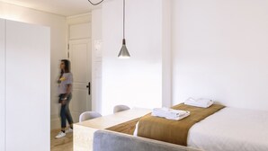 A modern hotel room with a bed, a dining table, and a hanging light fixture. -  ORM - 3 C´s Apartments (Porto)