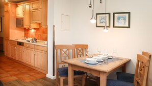 A kitchen with wooden cabinets, a microwave, and a dining table with chairs.