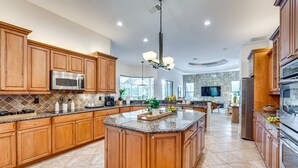 A spacious kitchen with wooden cabinets, granite countertops, and stainless steel appliances. - 7 Mi to Great Wolf Lodge Water Park: Luxury House (Naples)