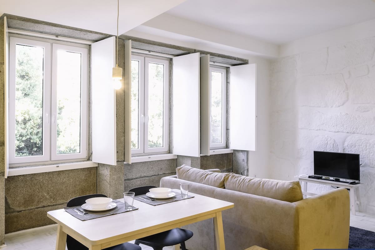 A modern living space with a dining area, sofa, and TV.