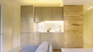 A compact kitchen with wooden cabinetry, a countertop, and a built-in oven.
