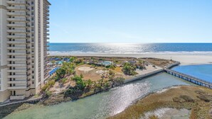 Un hôtel de grande hauteur offrant une vue sur la plage et donnant sur un petit plan d’eau.