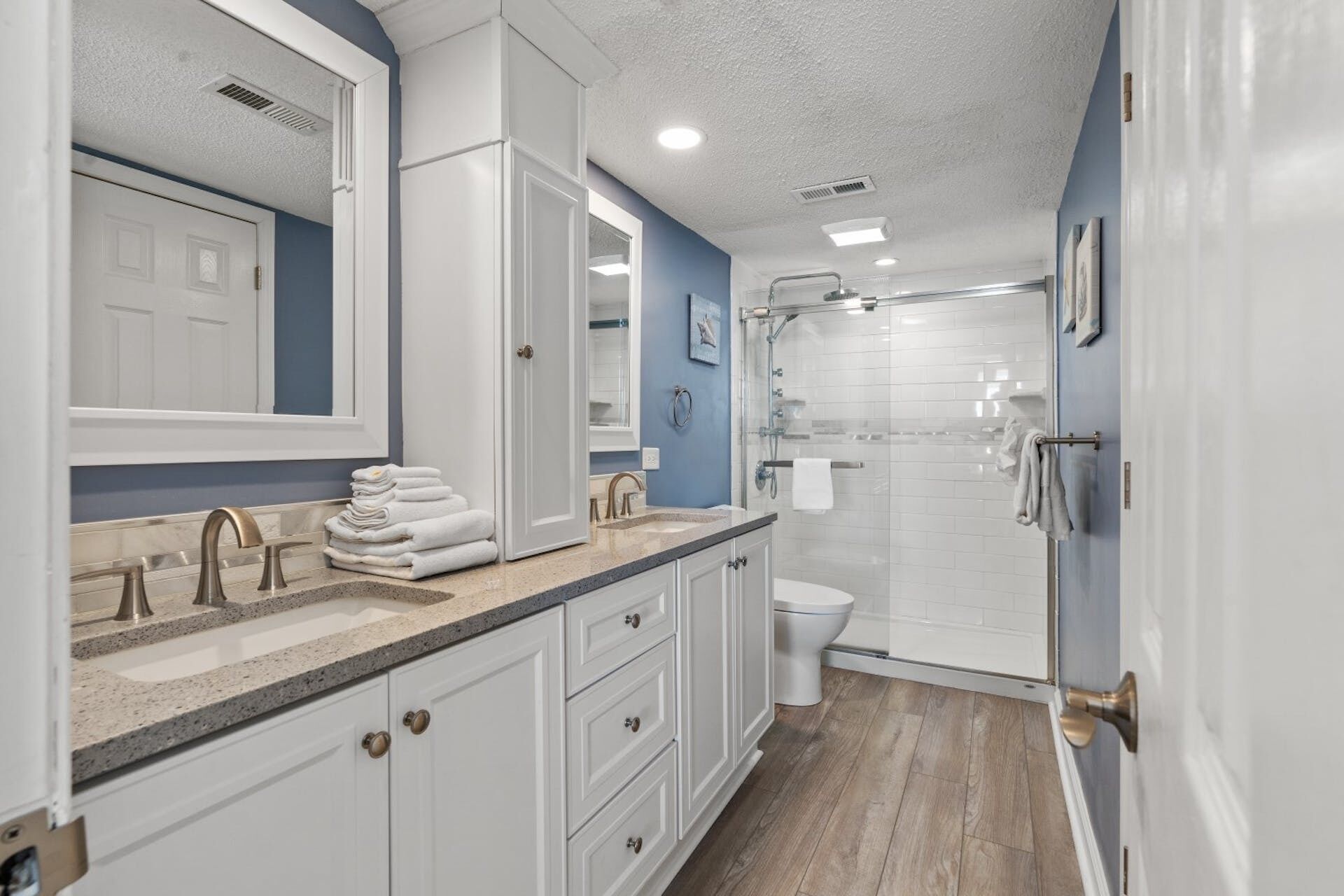A bathroom with a sink, mirror, and shower.