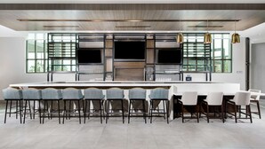 Une cuisine moderne dotée d’un grand îlot central, de tabourets de bar et d’un coin repas.