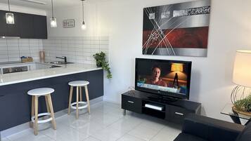Relax in a stylish living space with a kitchen area, flat-screen TV, and comfortable seating.