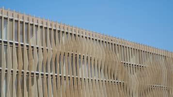 A building facade with a series of vertical slats and windows.