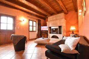 A living room with a fireplace, a sofa, a coffee table, and a television. - Luxurious Holiday Home in Domme With Swimming Pool (Cenac-et-Saint-Julien)