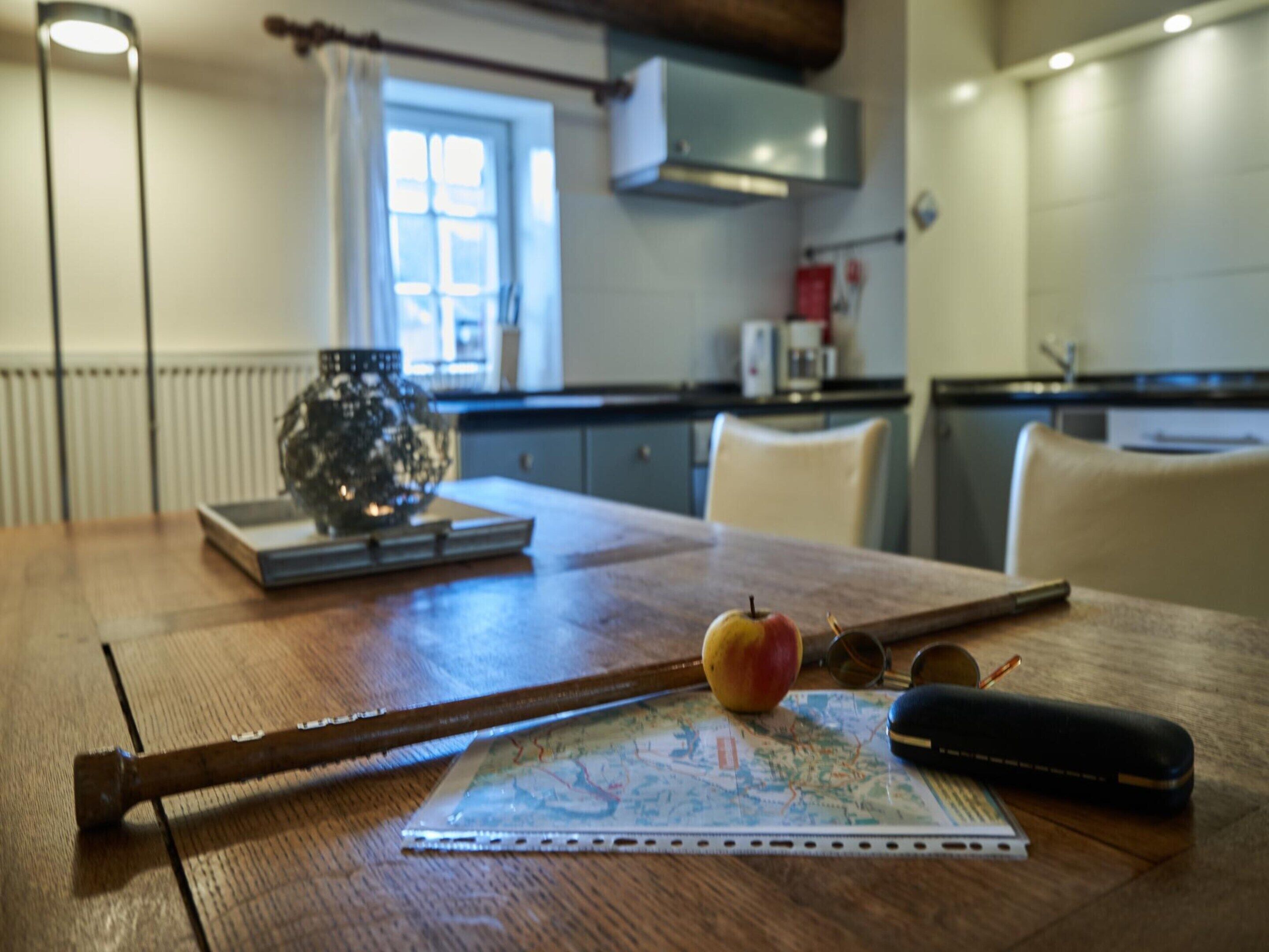 Een houten tafel met een kaart, een bril en een hamer.