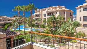 Un quartier résidentiel comprenant plusieurs immeubles d’appartements, une piscine et des palmiers.