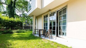 A modern building with large windows and a well-maintained lawn. - Victus Apartamenty - Walor 2 (Sopot)