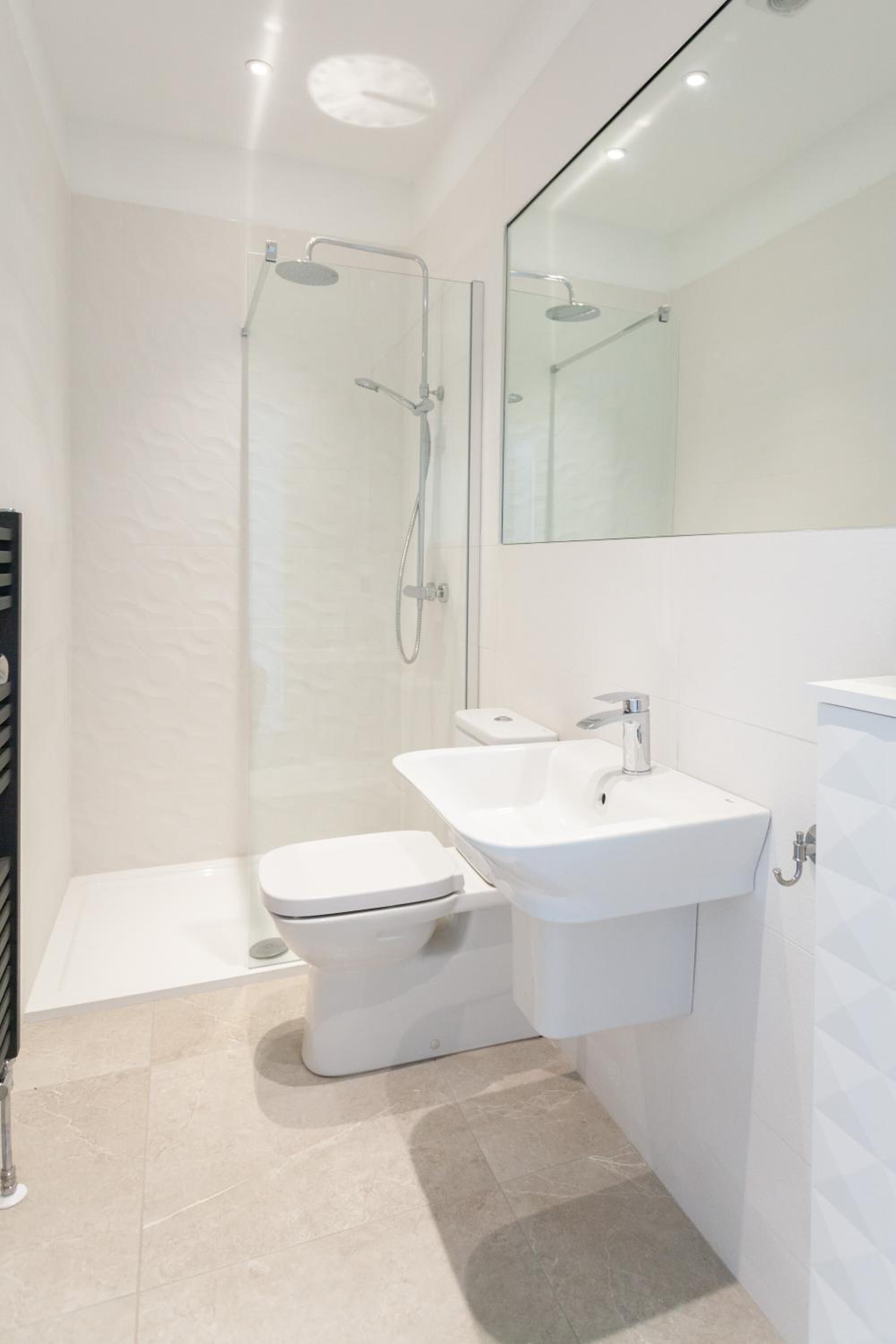 Un baño moderno con ducha, inodoro y lavamanos.