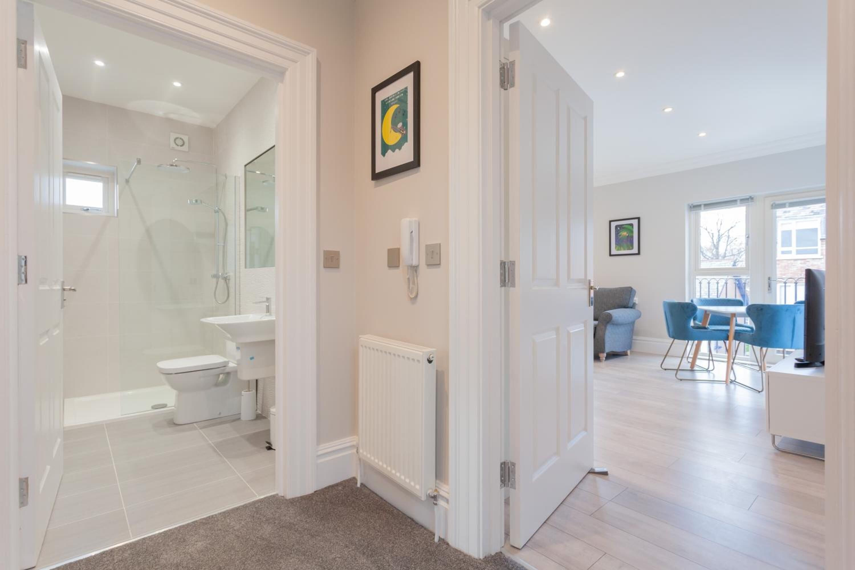 A modern bathroom with a shower, toilet, and sink.