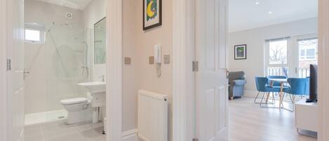 A modern bathroom with a shower, toilet, and sink.