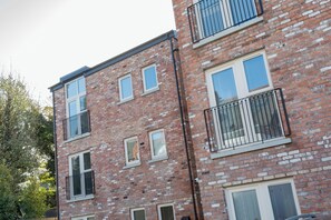 A multi-story brick building with balconies and windows.