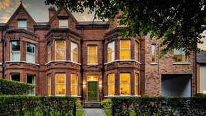 A Victorian-style brick house with bay windows, a green door, and a well-maintained front garden. - The Ulsterville Residences (Belfast)
