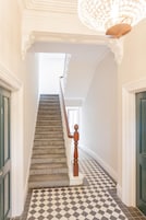 Una escalera con barandilla de madera que da a un rellano.