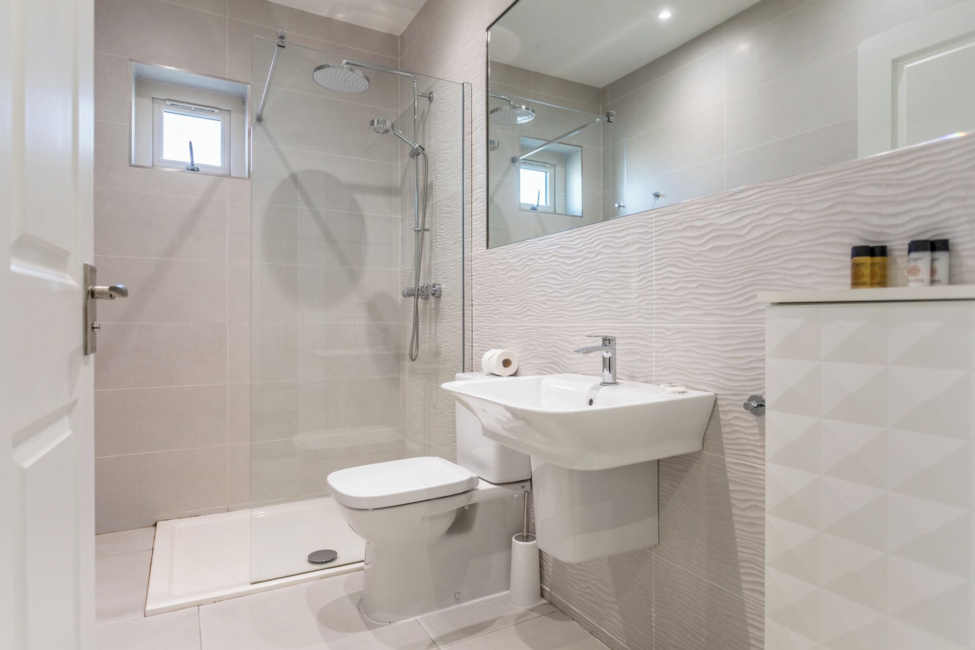 Un bagno moderno con cabina doccia, un water e un lavandino.