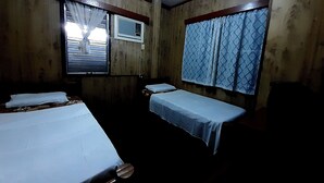 Une chambre avec deux lits, une fenêtre avec des rideaux et un climatiseur fixé au mur.