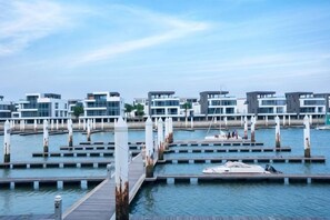 A marina with multiple docks, a wooden pier, and modern buildings with large windows. - Putian Hotel (Xiamen Mingfa Plaza) (Xiamen)