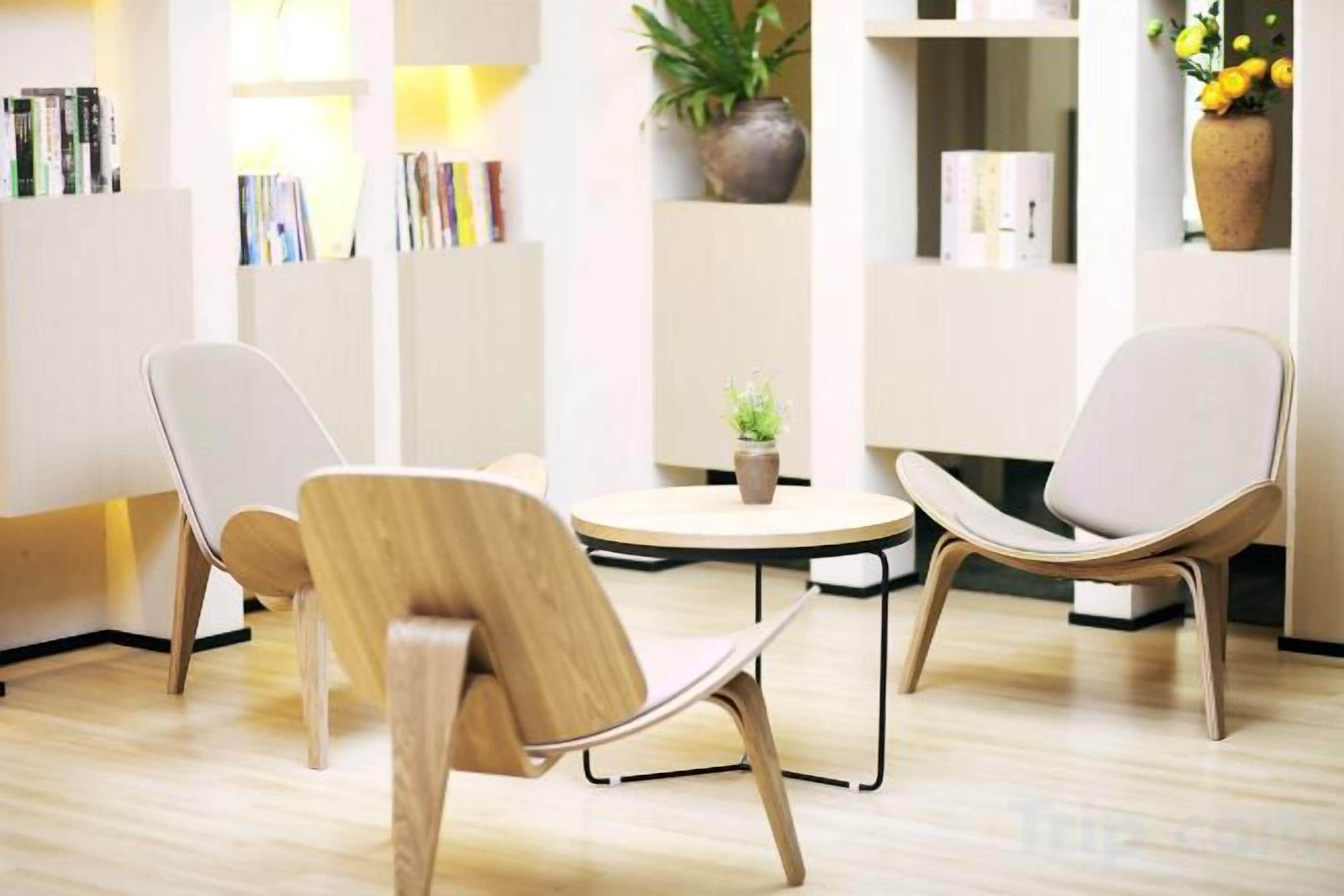 Un intérieur moderne avec deux chaises, une petite table et des étagères.