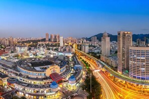 A cityscape with a roundabout, high-rise buildings, and a Ferris wheel. - Putian Hotel (Xiamen Mingfa Plaza) (Xiamen)
