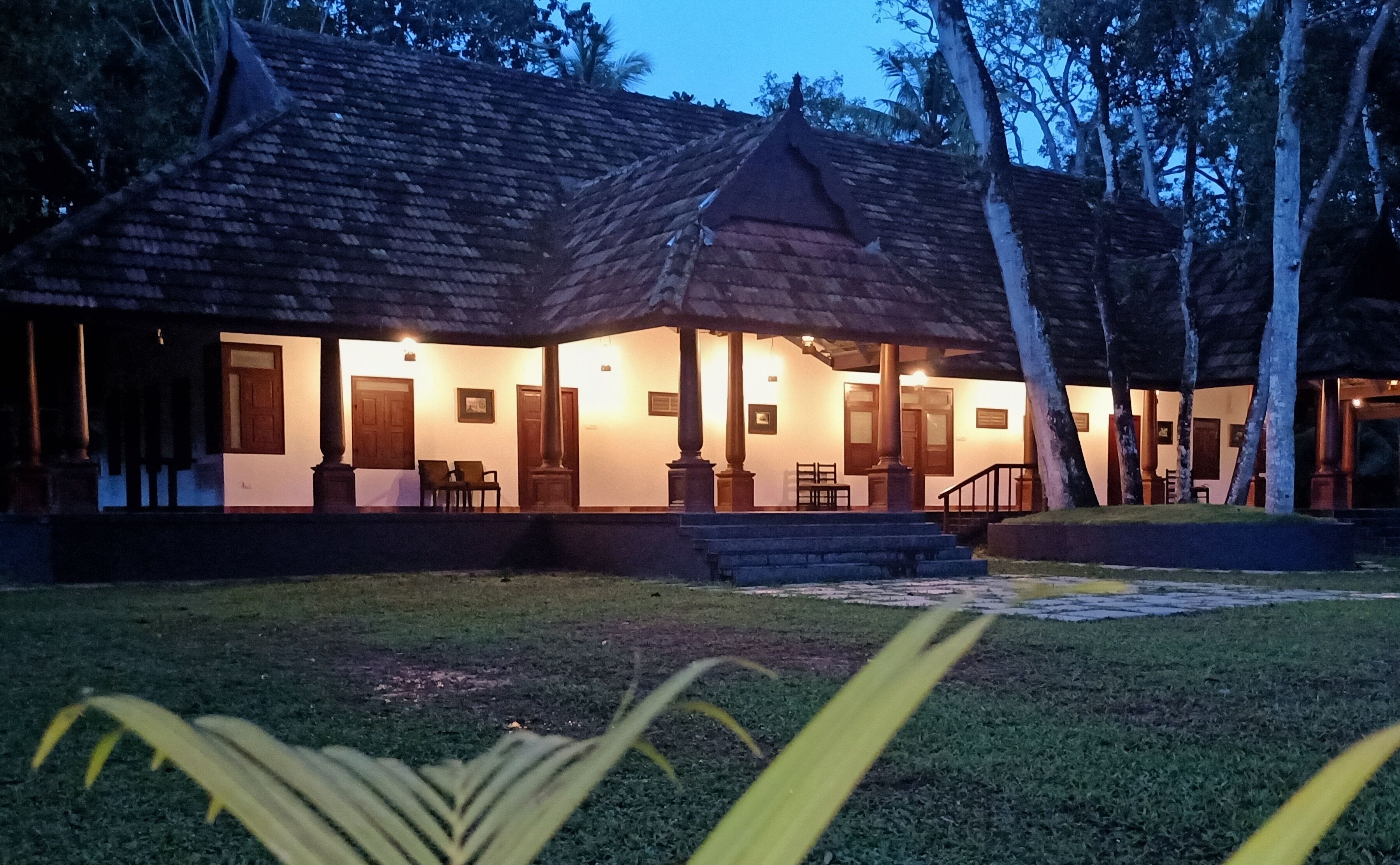 A traditional-style building with a tiled roof, multiple doors, and a covered porch area.