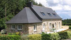 A stone house with a sloped roof, two skylights, and a small patio with a table and chairs. - Home for 7 Guests in Plouvara (Plouvara)