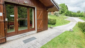 A wooden building with large glass doors, a paved entrance, and a pathway leading to a road. - Chalet in Lotharingen Near Forest & Ski Lift (La Bresse)
