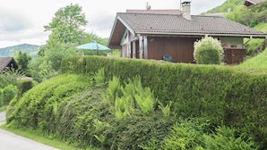 A rural house with a tiled roof, surrounded by lush greenery and a hedge. - Chalet in Lotharingen Near Forest & Ski Lift (La Bresse)