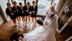 A wedding reception with a bride in a white gown, surrounded by bridesmaids in black, and guests in the background. - Luxury Stunning 5 Bed Barn Conversion Near Chester (Chester)