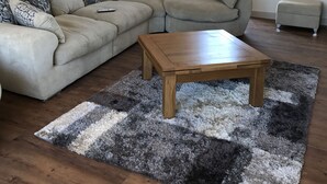 A living room with a sectional sofa, a wooden coffee table, and a rug. - Luxury Stunning 5 Bed Barn Conversion Near Chester (Chester)