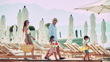 Relax on the beach with comfortable sun loungers and canopies for shade.