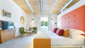 A modern hotel room with a large bed, a television, a dining area, and a view of the outdoors. - Da Rooms (Sorrento)